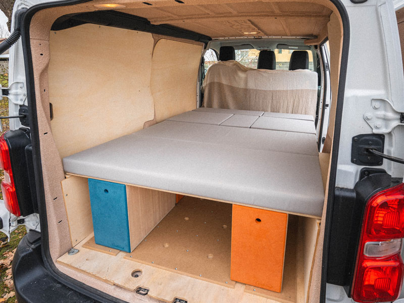 Slaapruimte in een omgebouwde Peugeot Expert tijdens een reis